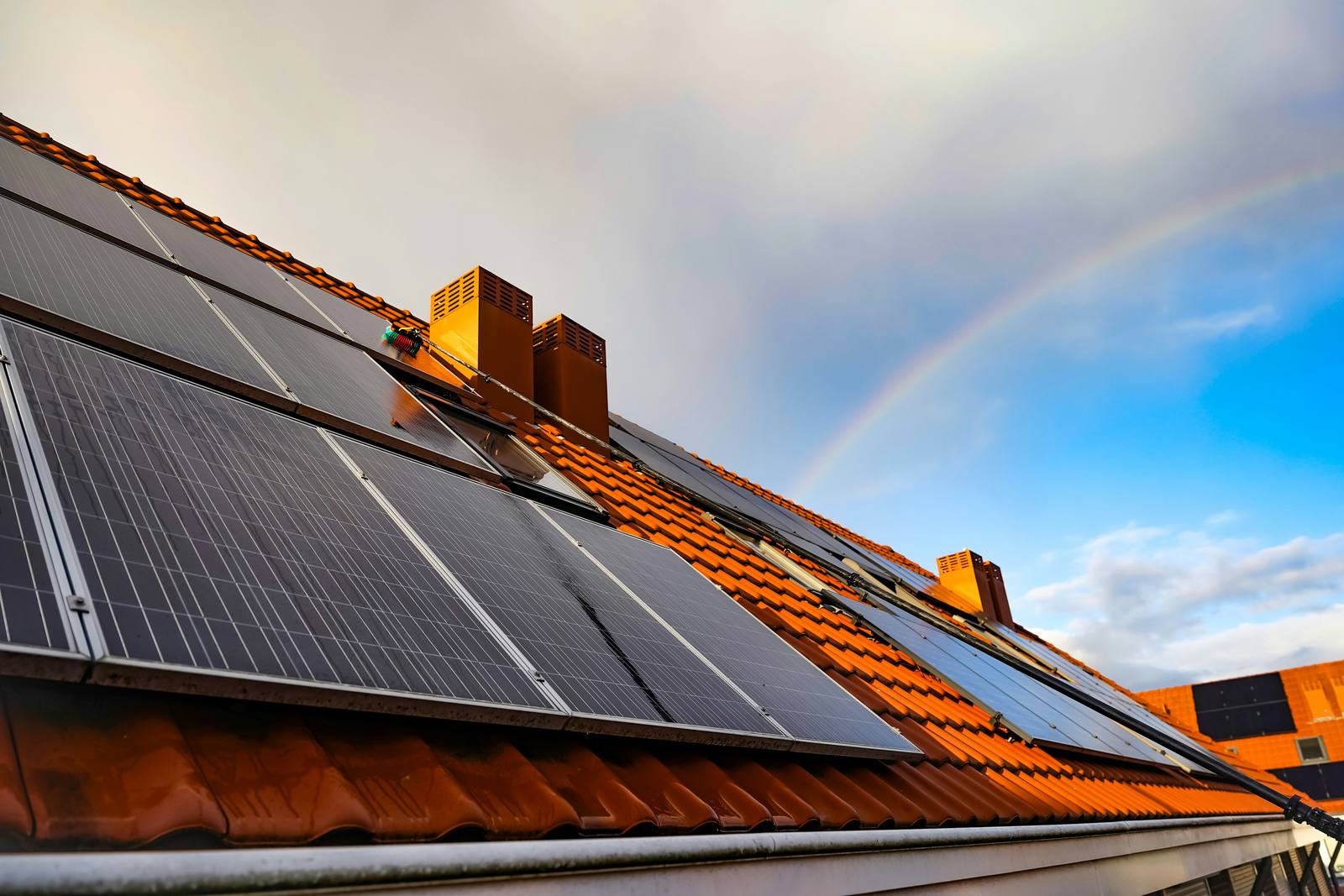 House with solar panels on the roof under a clear blue sky
