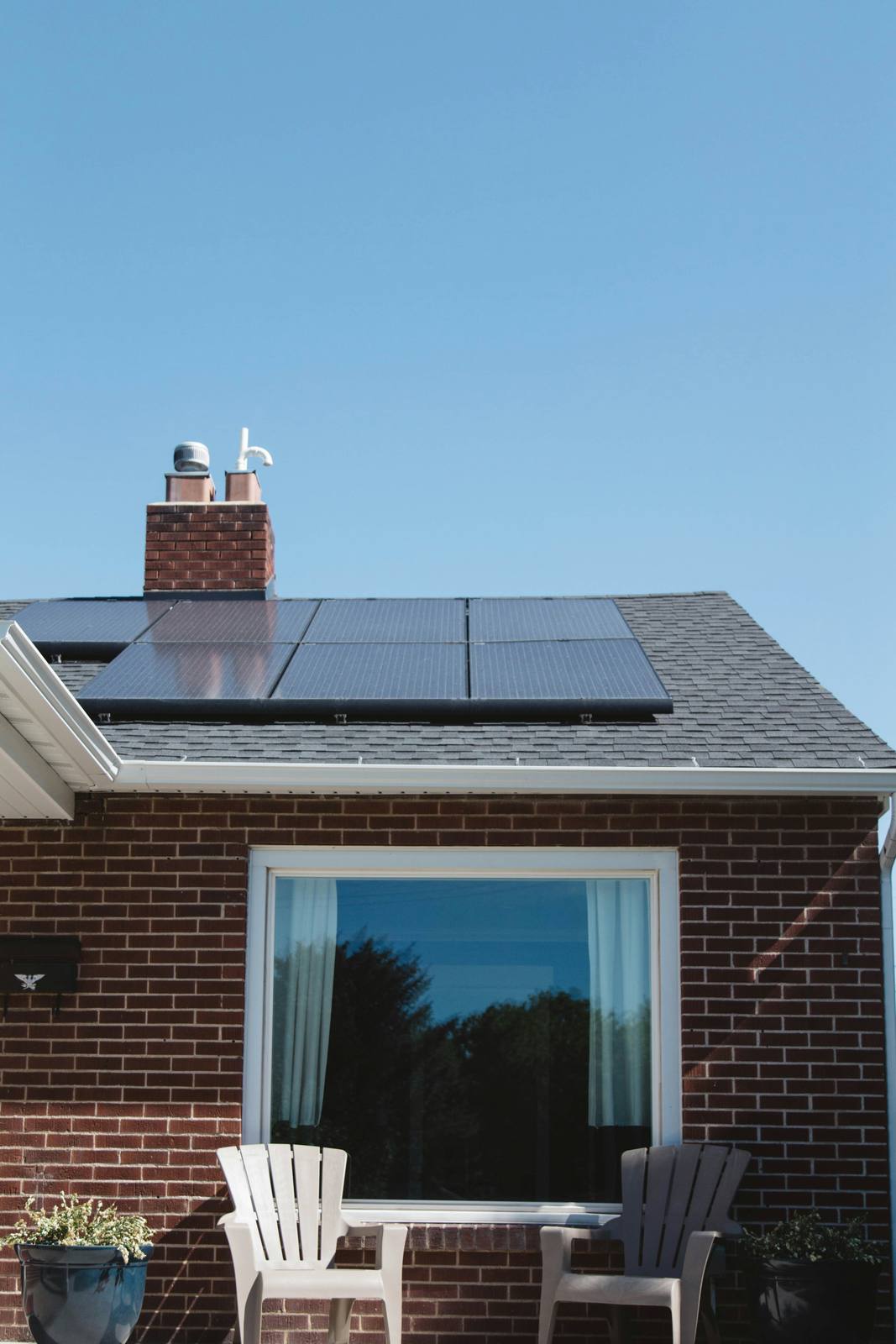 Home with rooftop solar panels and landscaped garden on a sunny day